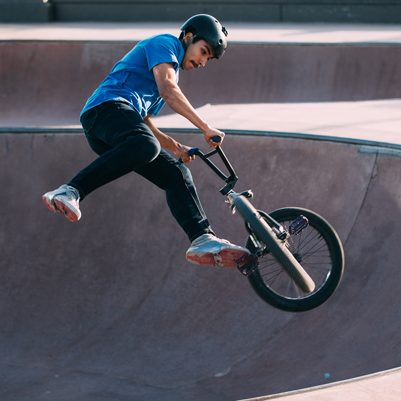 A teen doing a trick on a BMX bike.